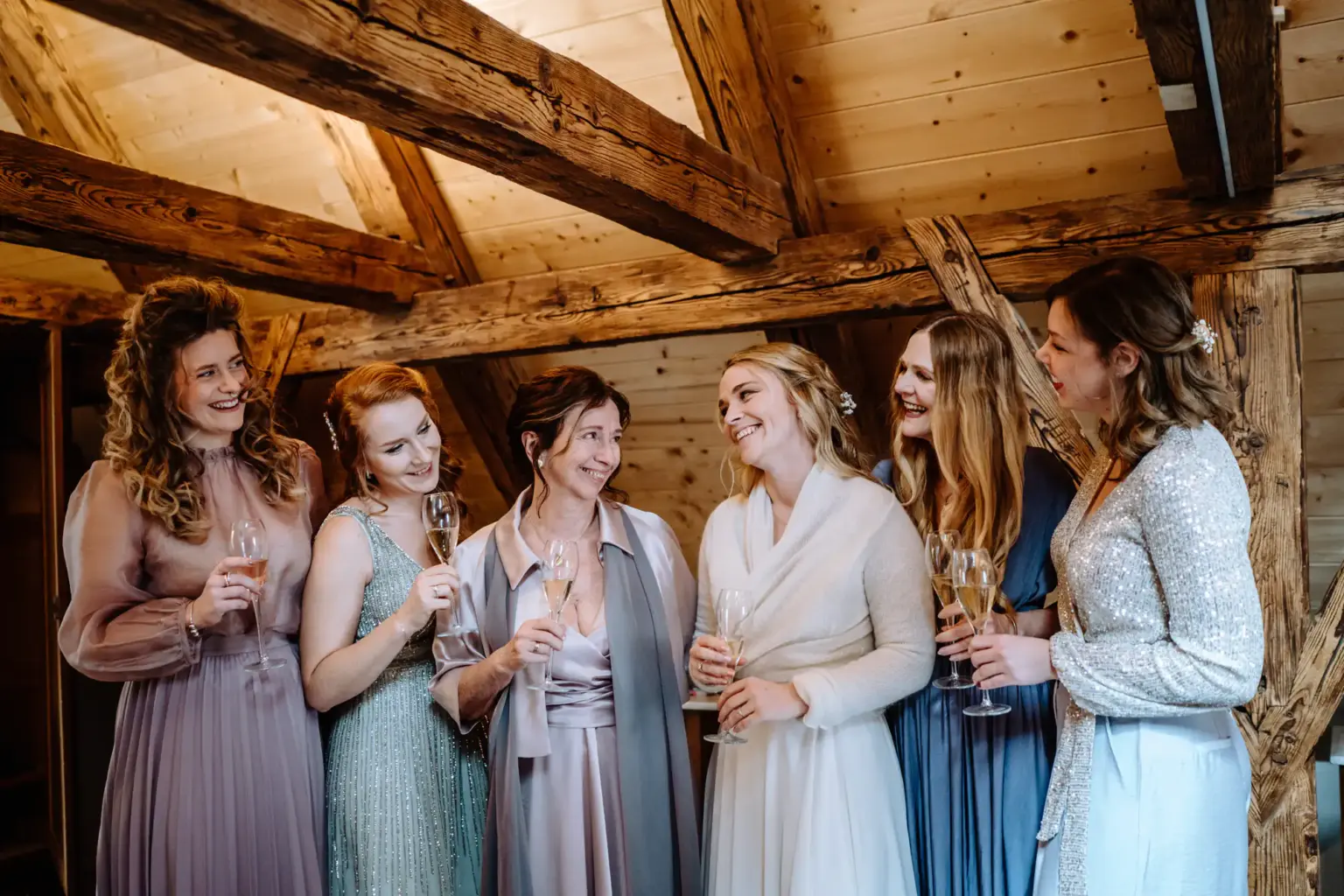 Braut mit Trauzeugin und Mama beim Anziehen des Hochzeitskleides