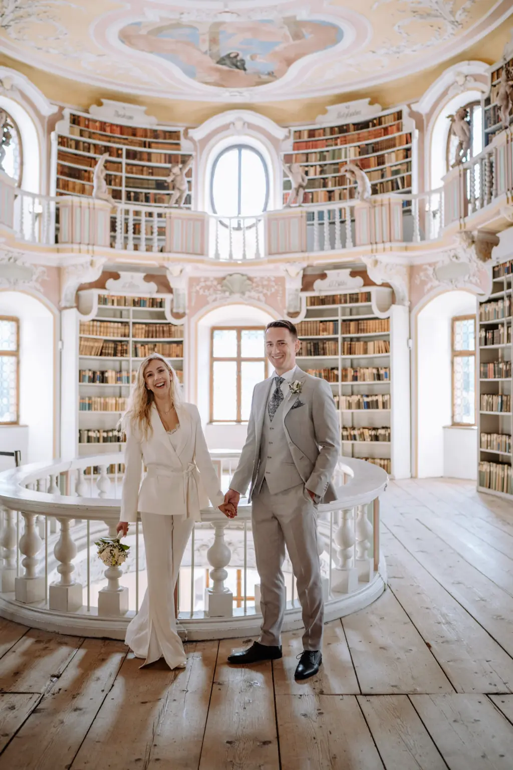 Brautpaar steht eng beieinander in der Bibliothek während des Shootings