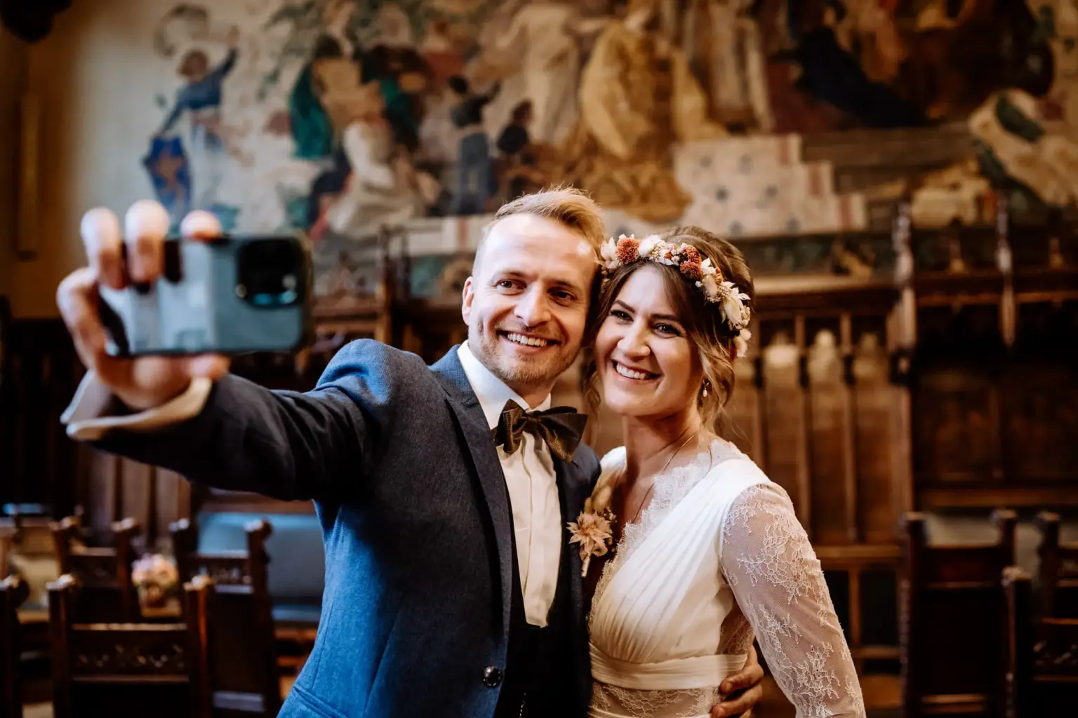 Braut und Bräutigam machen Selfie direkt nach der Trauung im kleinen Sitzungssaal