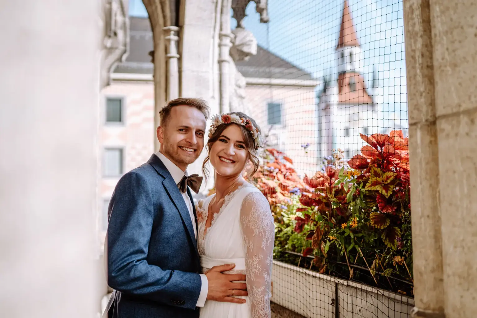 Glückliche Braut und Bräutigam auf dem Balkon vom Rathaus München am Marienplatz