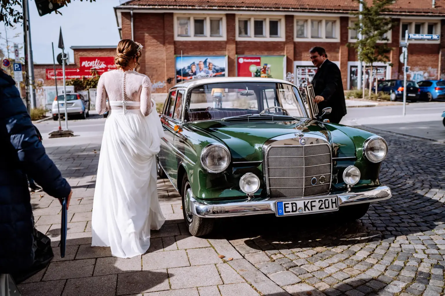 Braut und Bräutigam fahren im alten Mercedes zum Rathaus München am Marienplatz