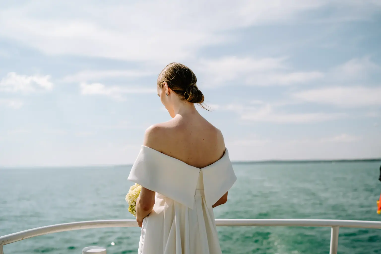 Braut steht an der Reling vom Schiff mit Blick über den Bodensee