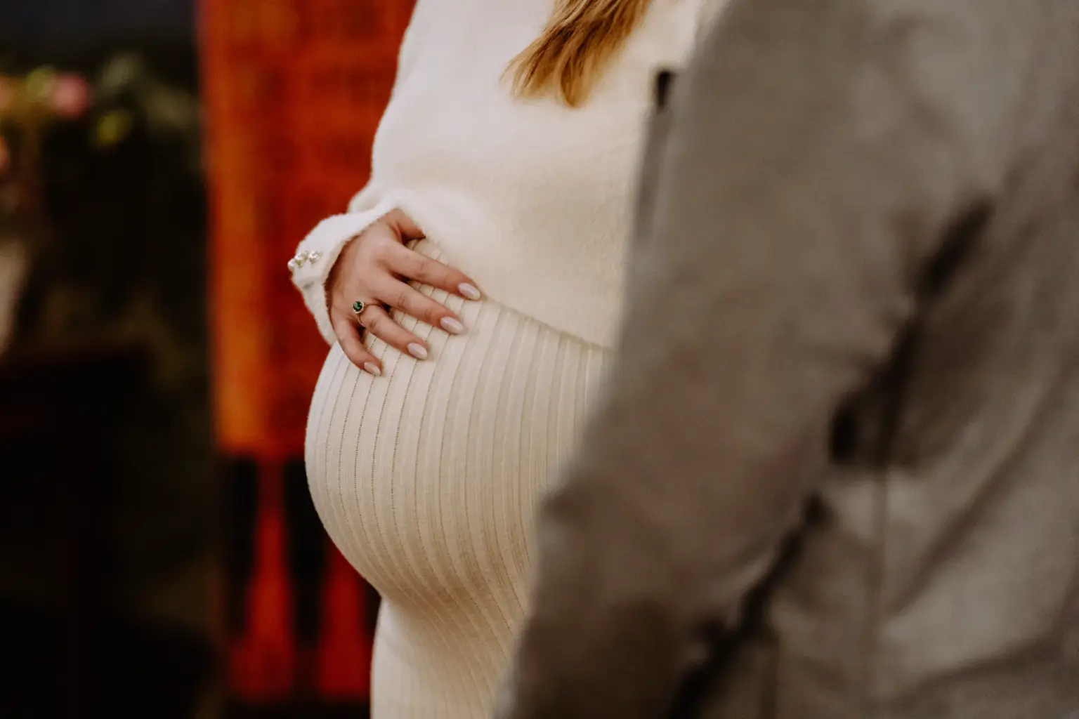 Detailfoto von der Hand auf dem Babybauch während der Trauung