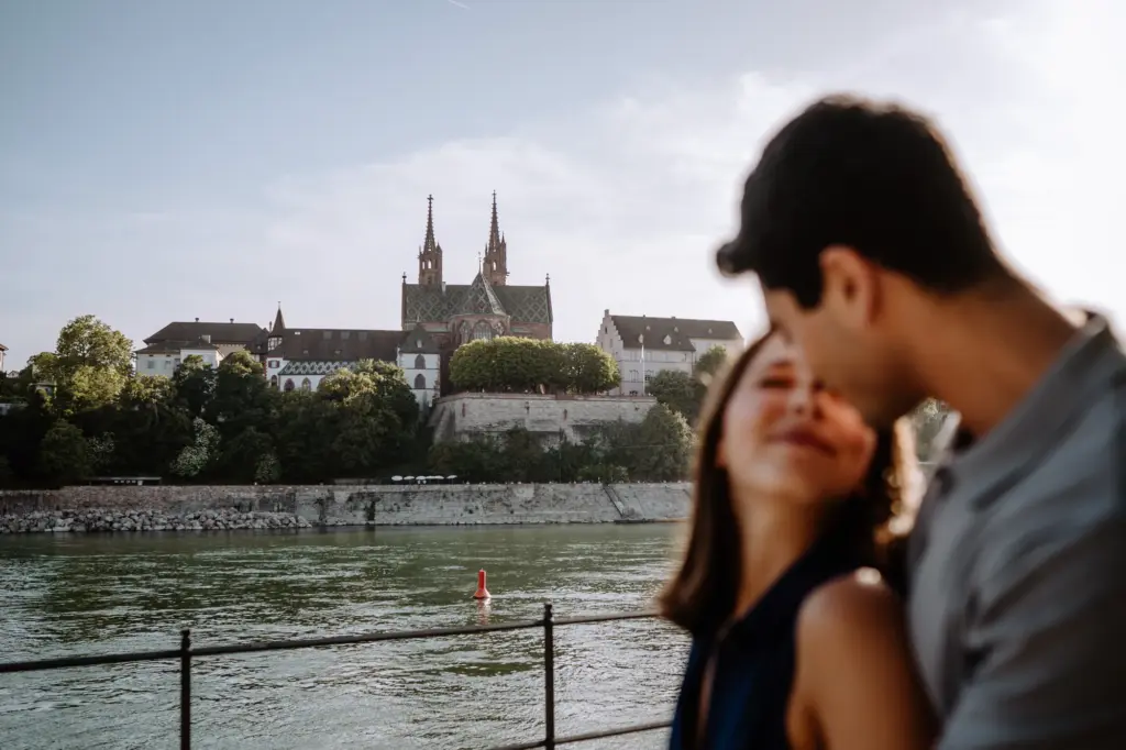 Paar im Vordergrund mit dem Basler Münster und dem Rhein im Hintergrund
