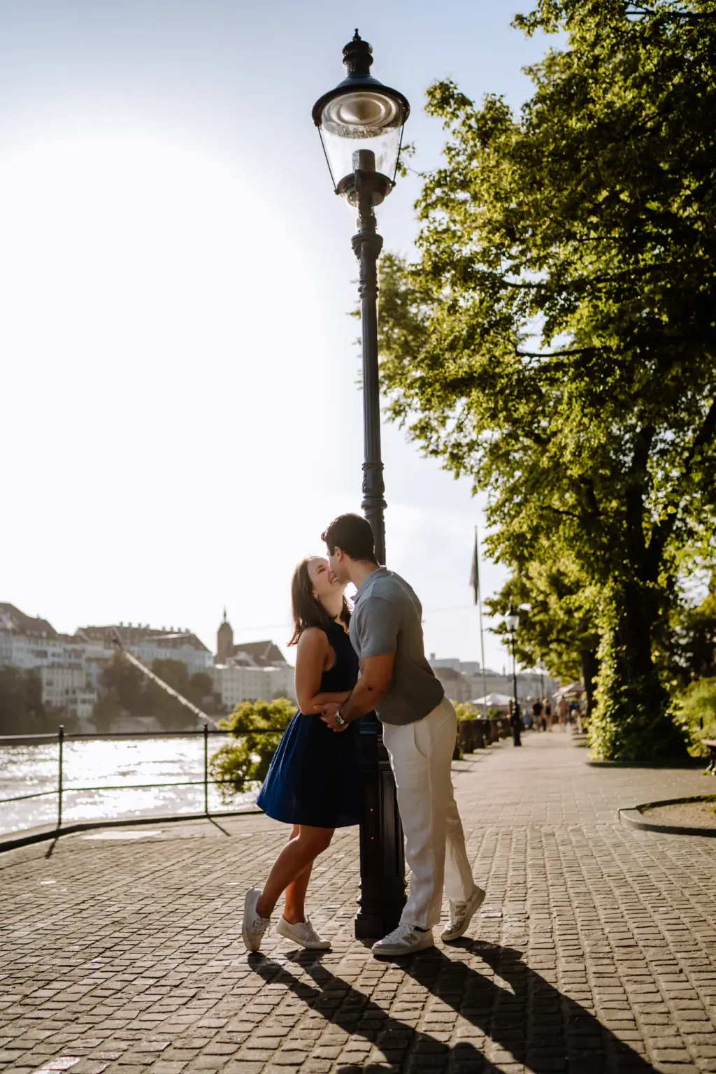 Paar küsst sich unter einer Laterne an der Basler Rheinpromenade