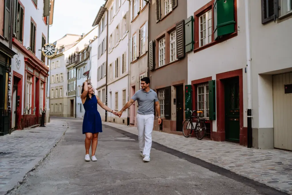 Paar hält sich an den Händen und lacht in einer Gasse der Basler Altstadt